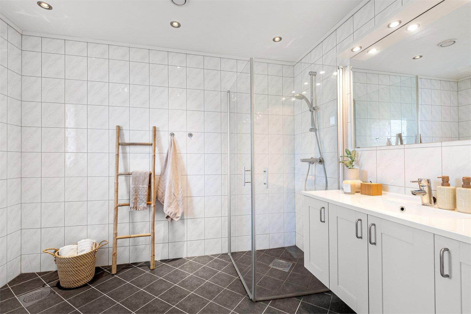 Flislagt bad i 1. etasje med gulvvarme, downlights og dusjhjørne med innfellbare glassdører.