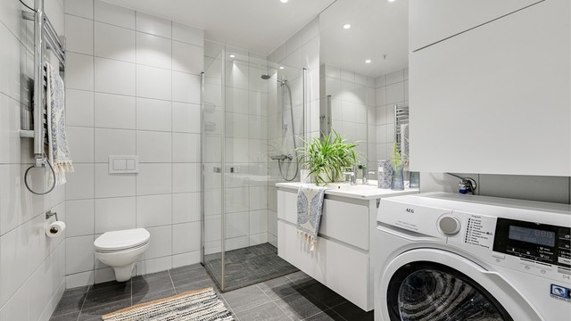 Lyst og trivelig bad med flislagte gulv og vegger, det er elektriske varmekabler i gulv.