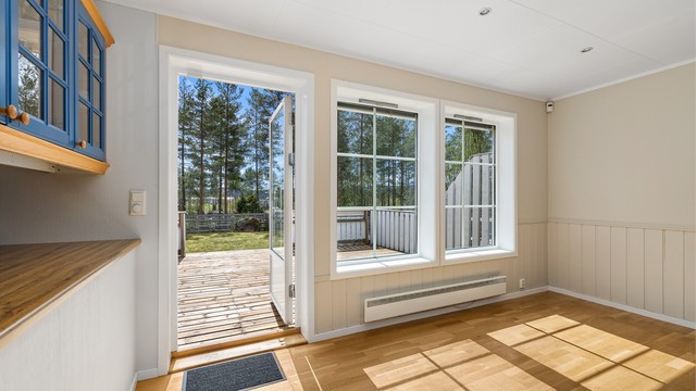 Vinduene i front vender rett ut mot hagen, og det er utgang til den solrike terrassen.