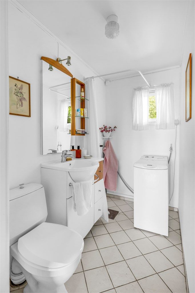 Flislagt bad med varmekabler, dusj, toalett og opplegg for vaskemaskin på øvre plan.