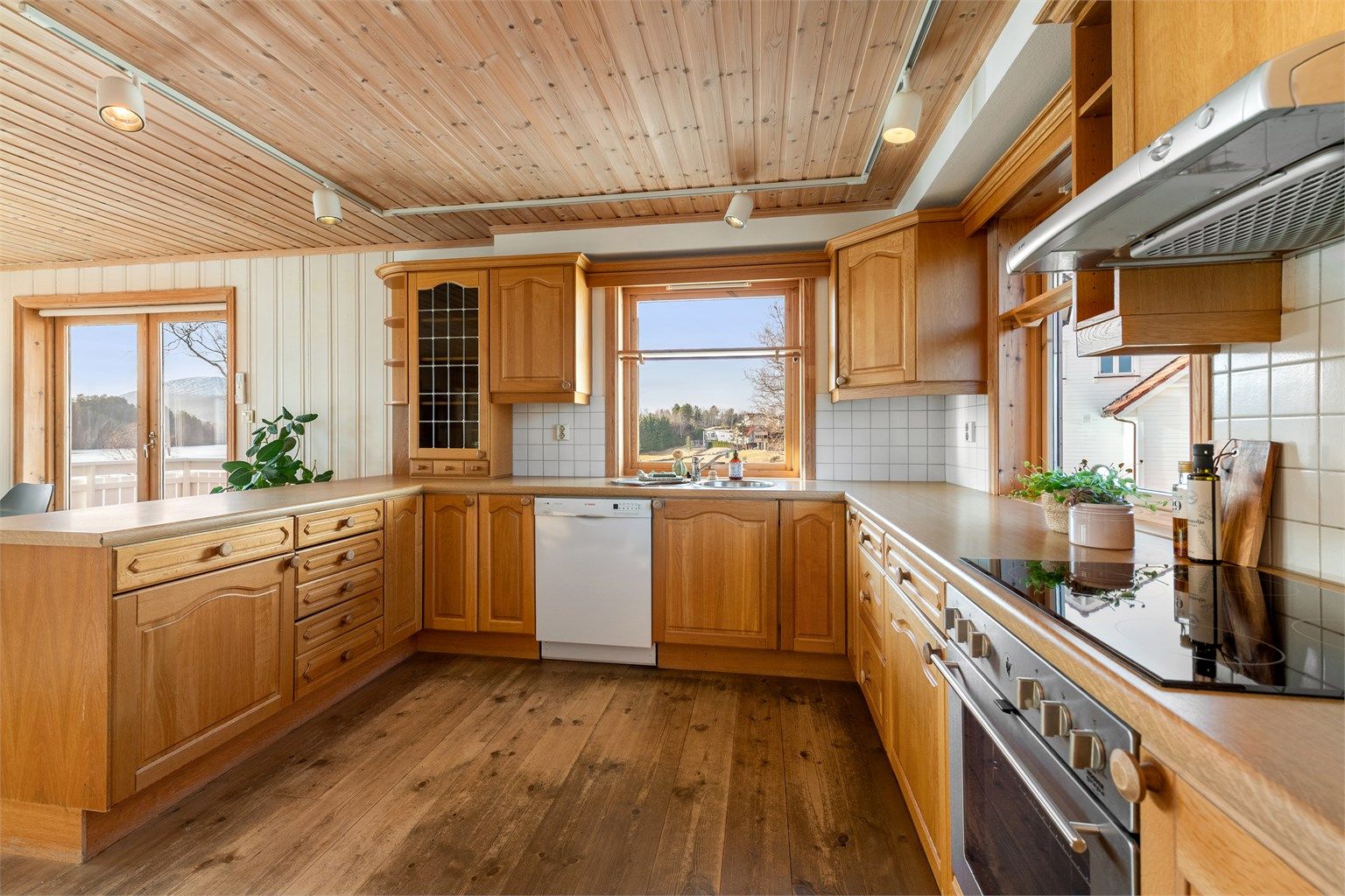 Kjøkkenet har kjøl/fryseskap, oppvaskmaskin og integrert platetopp og stekeovn. Det er kjøkkenventilator med avtrekk ut. Flott utsikt mot vest