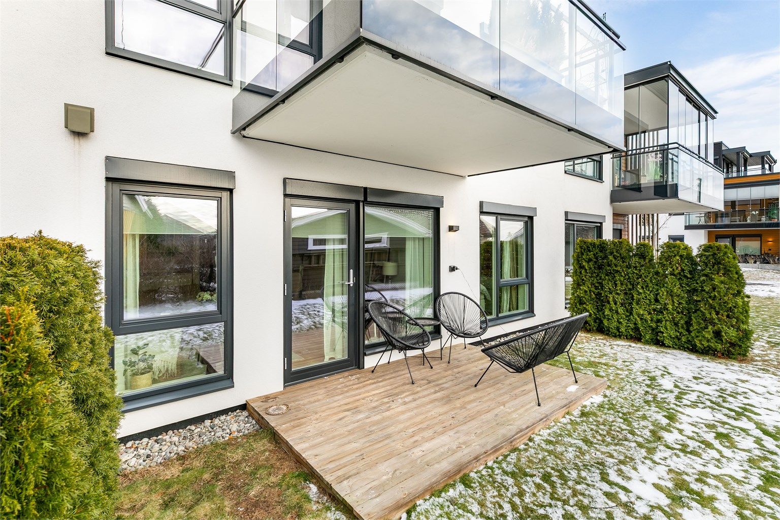 I årets varmere måneder er plattingen solfylt dagen gjennom. Over stuevinduene er kasser montert som forberedelse for eventuelle screens.