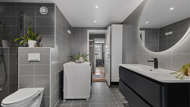 Delikat, helfliset bad med moderne innredning, vegghengt toalett og varme i gulvet.