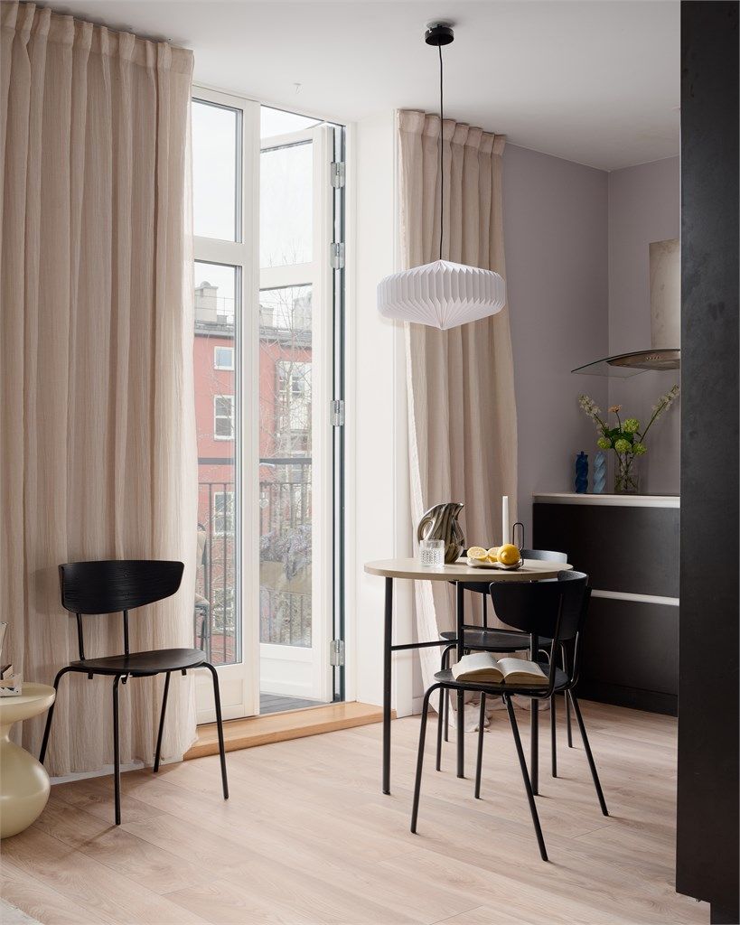 Ved balkongen er det plass til en fin spiseplass som bader i naturlig lys fra de store glassdørene.