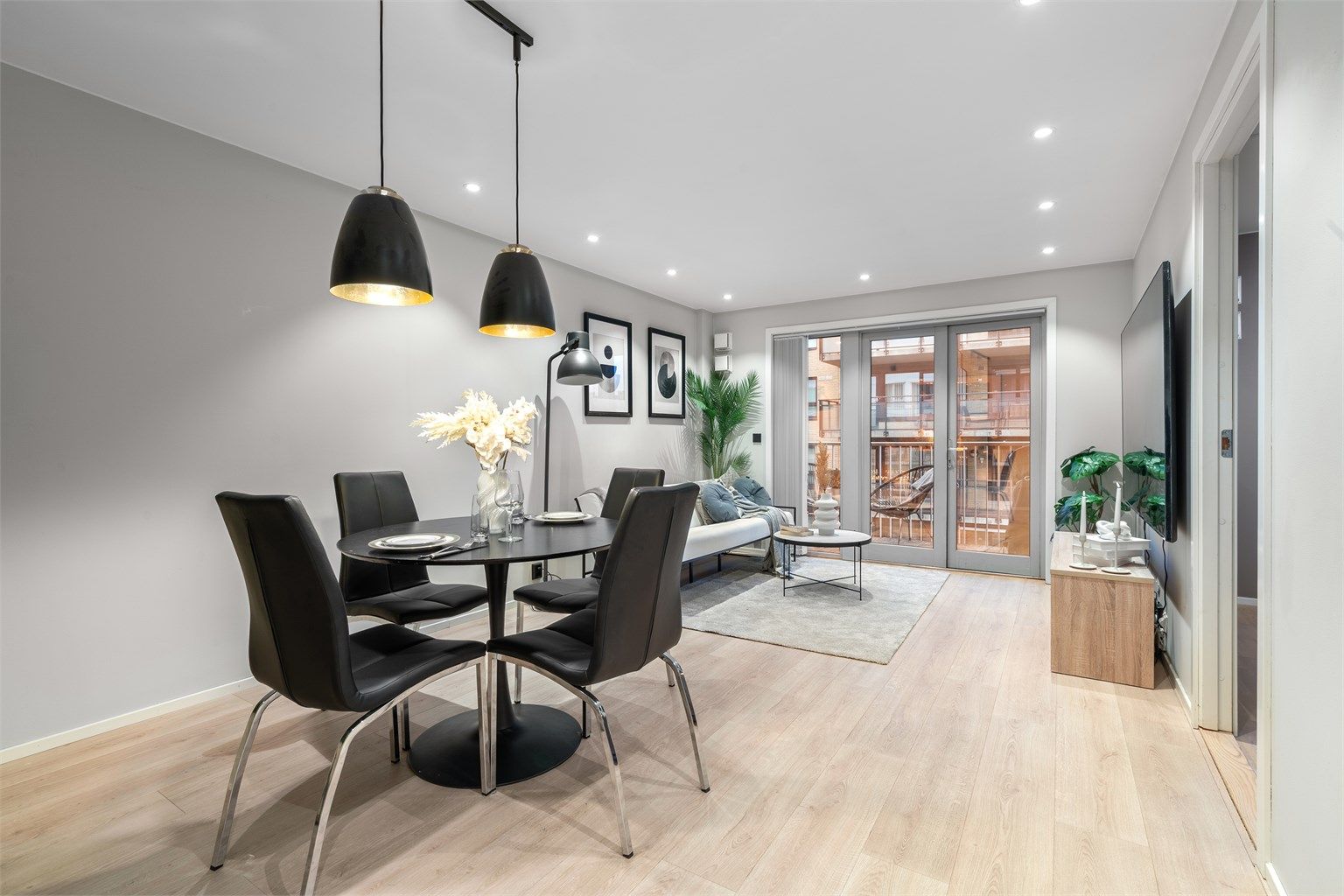 Åpen løsning mot kjøkken som gir en sosial og luftig romfølelse.