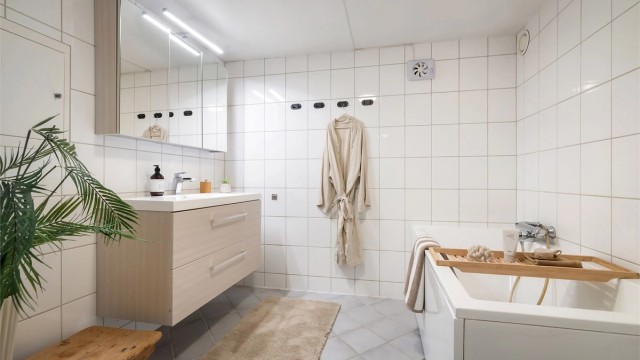 Badet har innredning med heldekkende servant og overskap med speil.