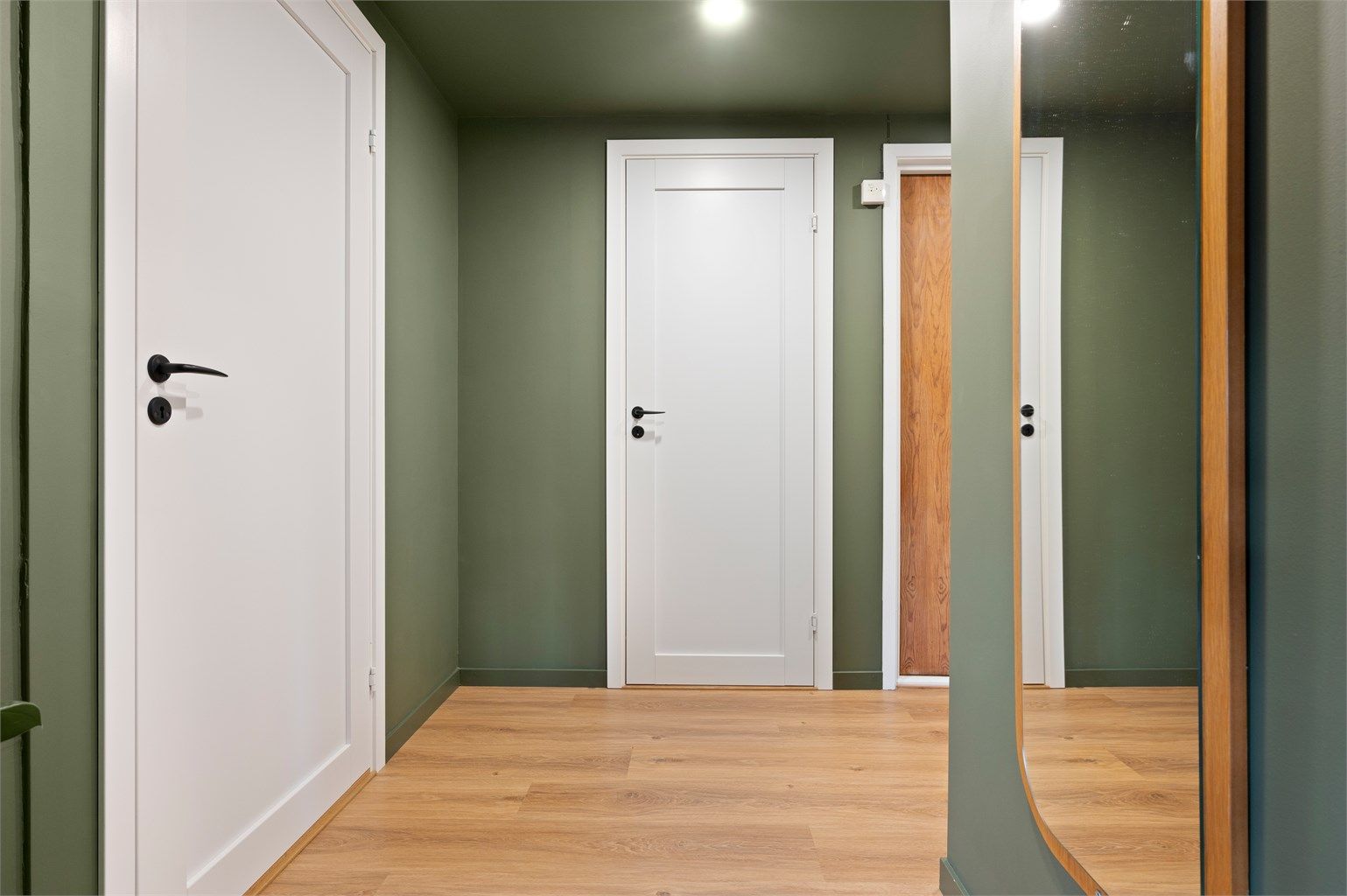 Leiligheten disponerer videre boder på til sammen 25 kvm i felles kjeller og loft med gode lagringsmuligheter. Gangen er malt i fargen Organic Green fra Jotun. Dørene er byttet til heltredører fra Swedoor. 