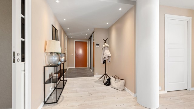 Gangen binder rommene sammen og har downlights i taket og vannbåren gulvvarme