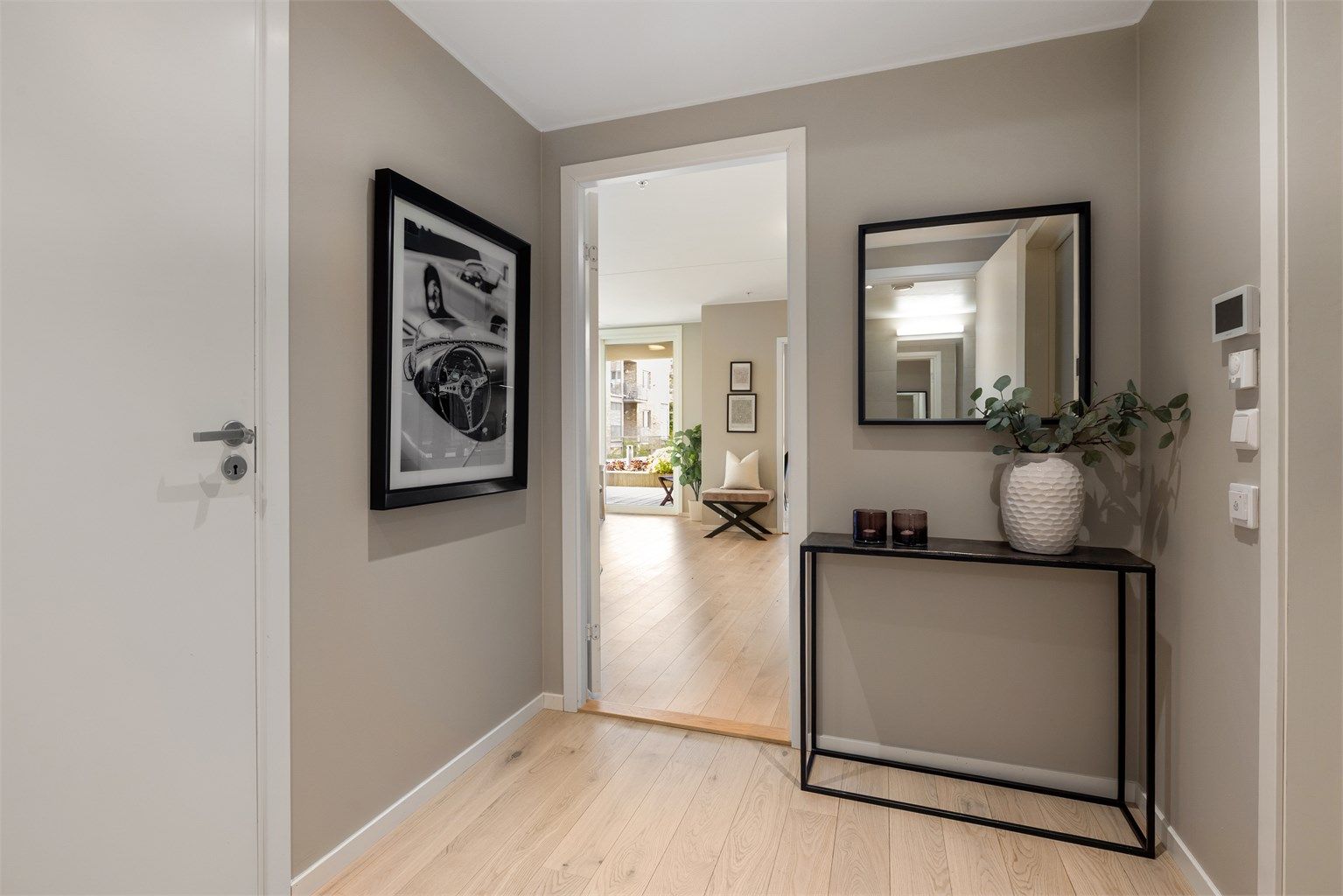 Romløsningen gjør at du får et naturlig overblikk over leilighetens åpne og lyse atmosfære allerede ved inngangsdøren.