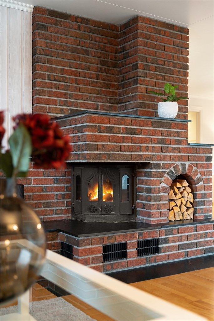 Den sentralt plasserte peisovnen fra byggeår skaper en naturlig samlingsplass i stuen.