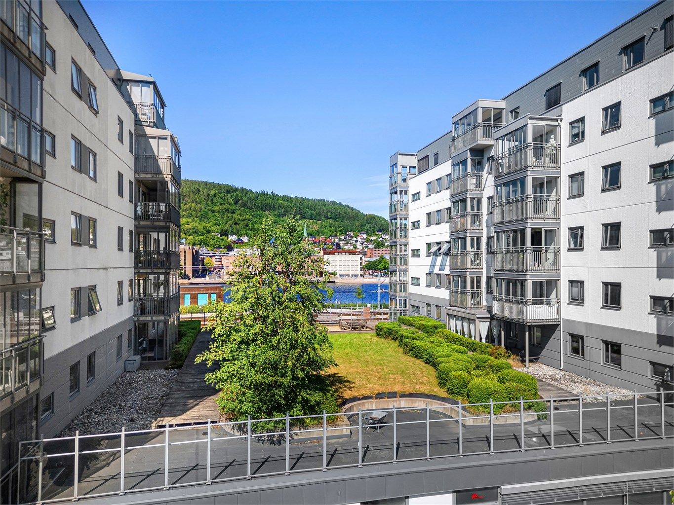 Mellom blokkene er det to felles atrium som er opparbeidet med gressplen, prydbusker, hekk, sandkasser og hyggelige sitteplasser.