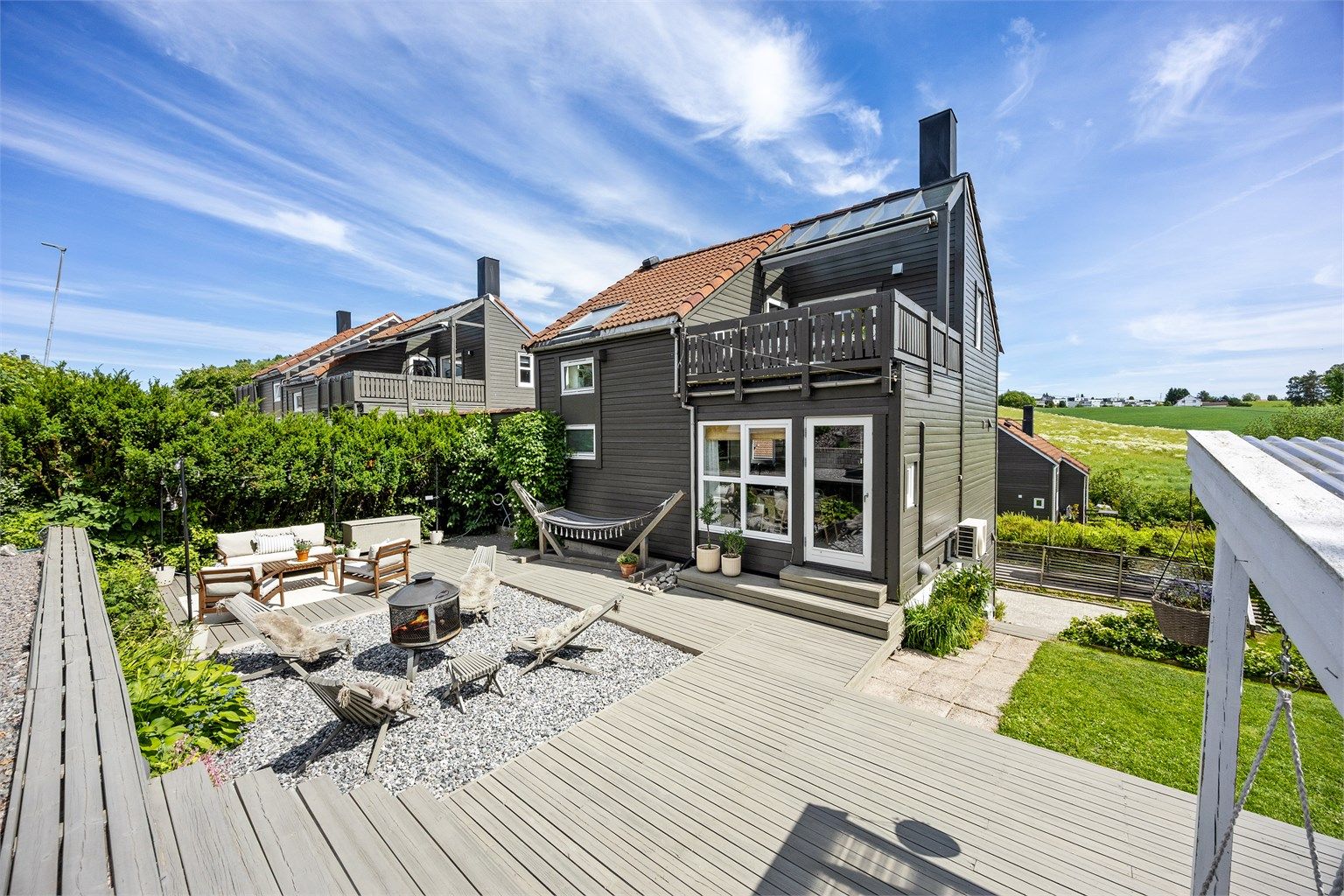 Boligen har en stor terrasse på ca. 77 m² med flere soner og utekjøkken fra 2024.