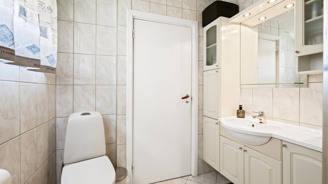 Badet har gulvstående toalett fra 2021 og et dusjkabinett fra 2025.