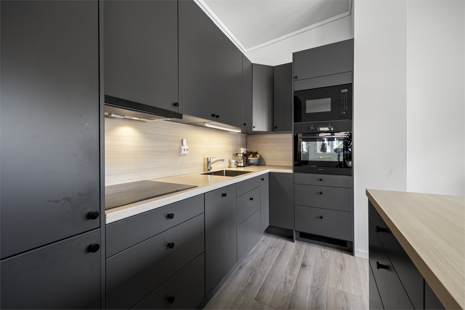 Kjøkken med integrerte hvitevarer som medfølger i handelen. Det er oppvaskmaskin, mikro, stekeovn, koketopp og kjøl/frys.