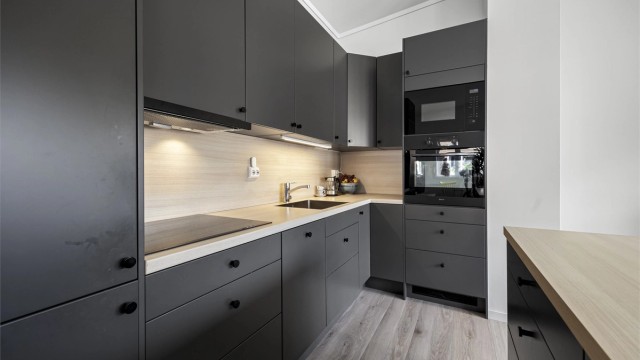 Kjøkken med integrerte hvitevarer som medfølger i handelen. Det er oppvaskmaskin, mikro, stekeovn, koketopp og kjøl/frys.