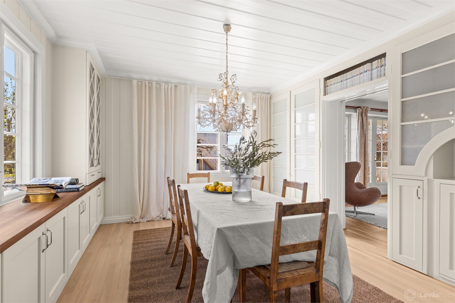 Spisestuedelen viderefører den samme stilen med plassbygde vitrineskap, i kombinasjon med originale skap ivaretar rommets særpreg og historie