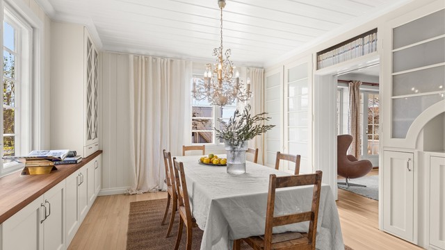 Spisestuedelen viderefører den samme stilen med plassbygde vitrineskap, i kombinasjon med originale skap ivaretar rommets særpreg og historie