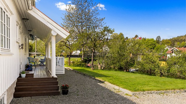 Tomten er opparbeidet med gruset gårdsplass og plenarealer.
