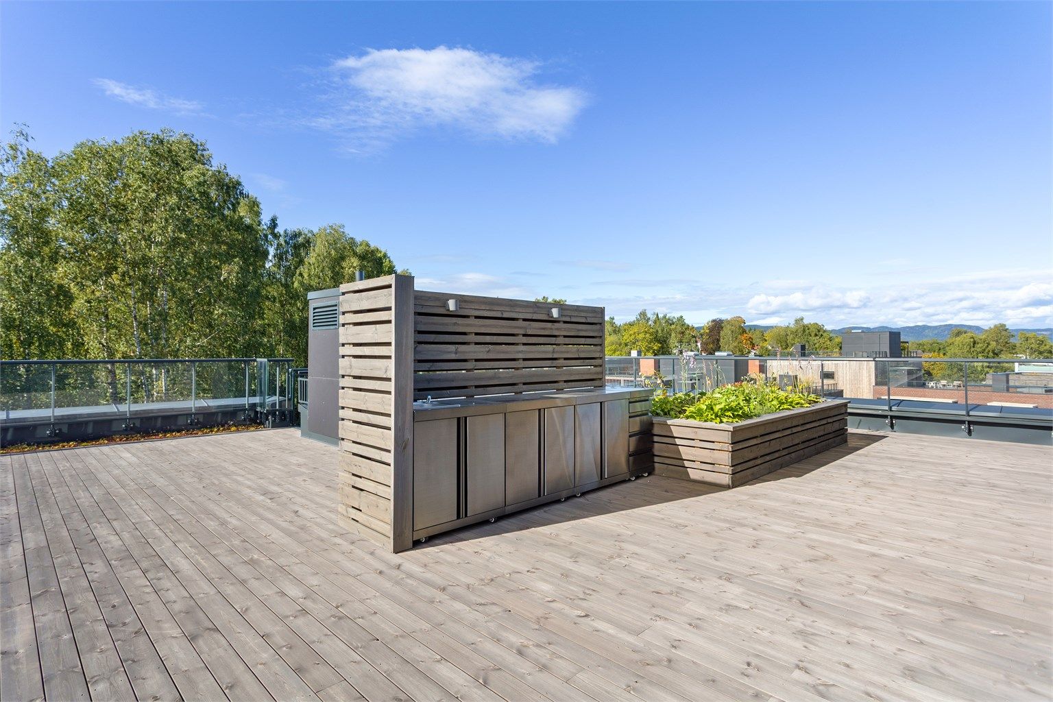 Den store private takterrassen på hele 99 kvm byr bl.a. på et utekjøkken med innlagt vann, utebelysning og god plass til sittegrupper.