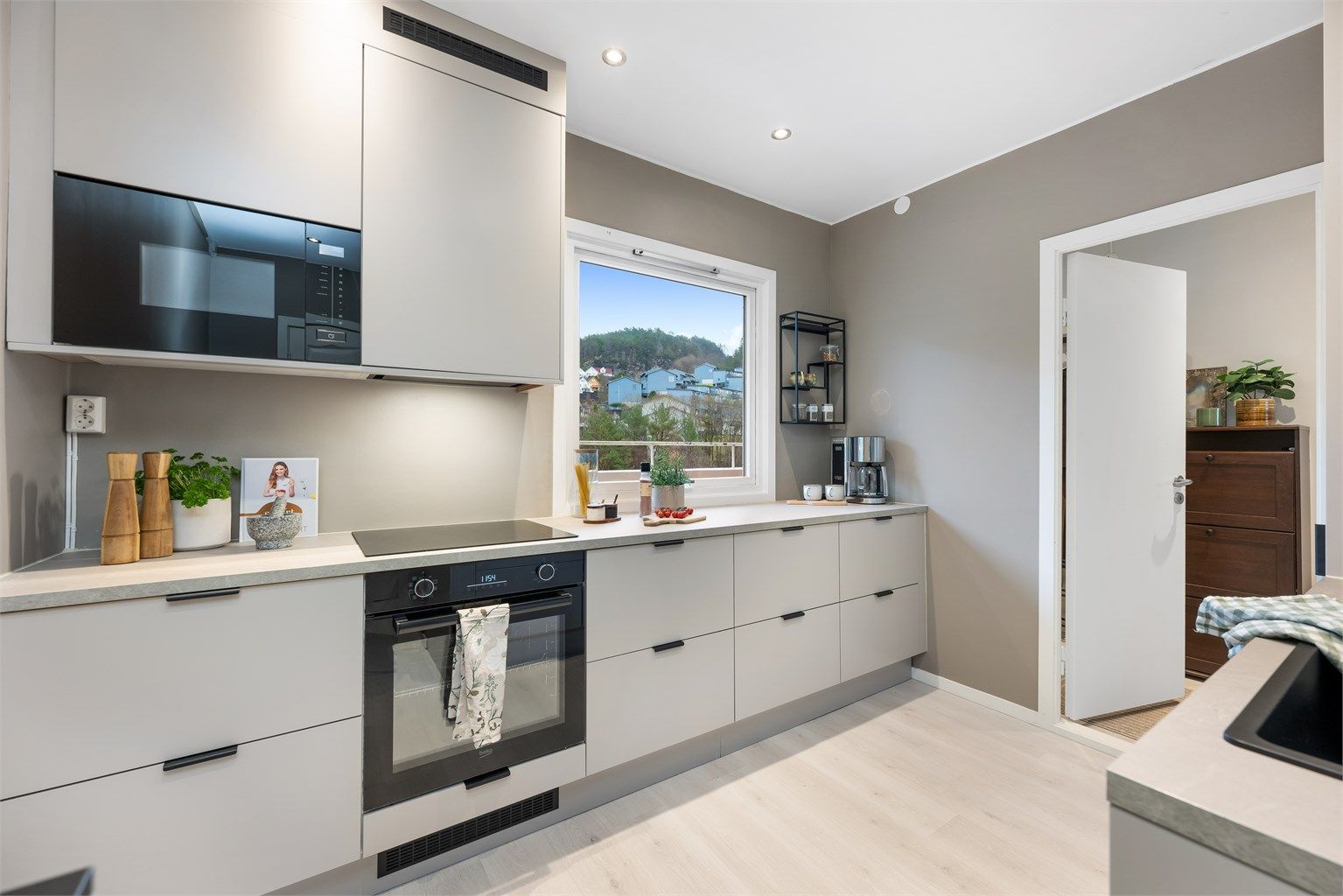 Integrert stekeovn, platetopp, oppvaskmaskin, mikrobølgeovn og kjøleskap med fryser. Hvitevarene medfølger. 