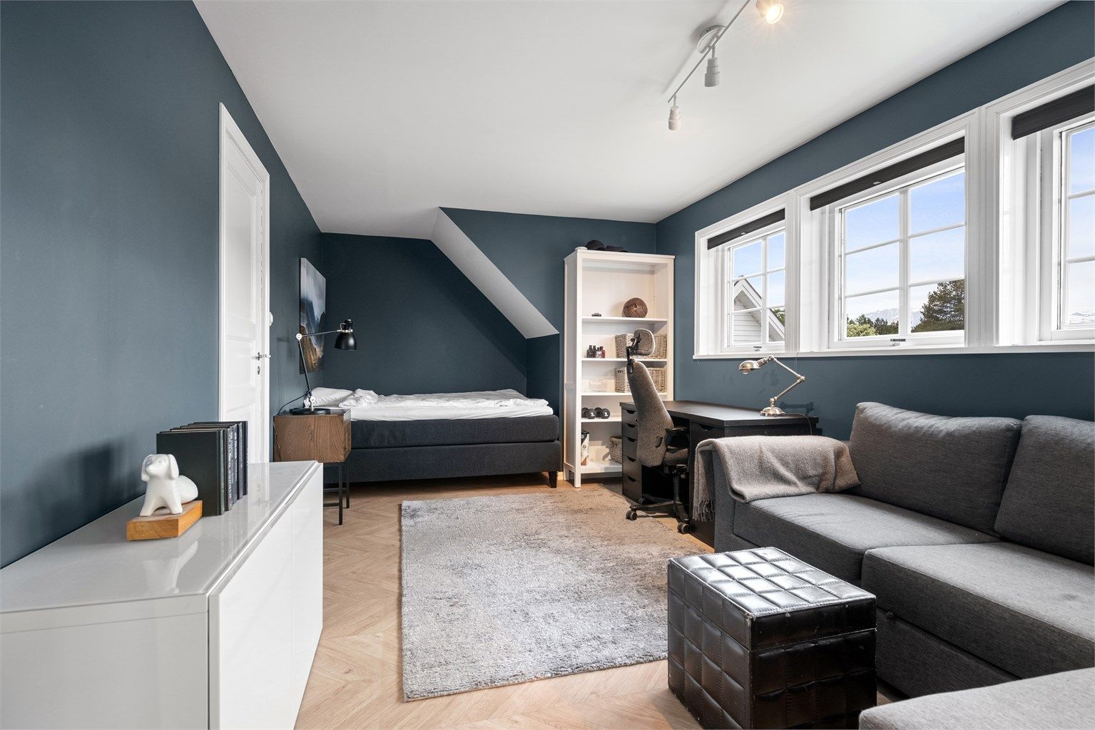 Et av soverommene i loftsetasjen, med plass til både seng og en liten sittegruppe.