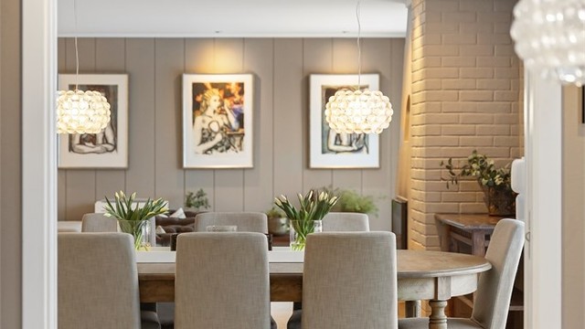 Et åpent utsyn fra spisestuen mot kjøkkenet skaper en sosial og inkluderende atmosfære.