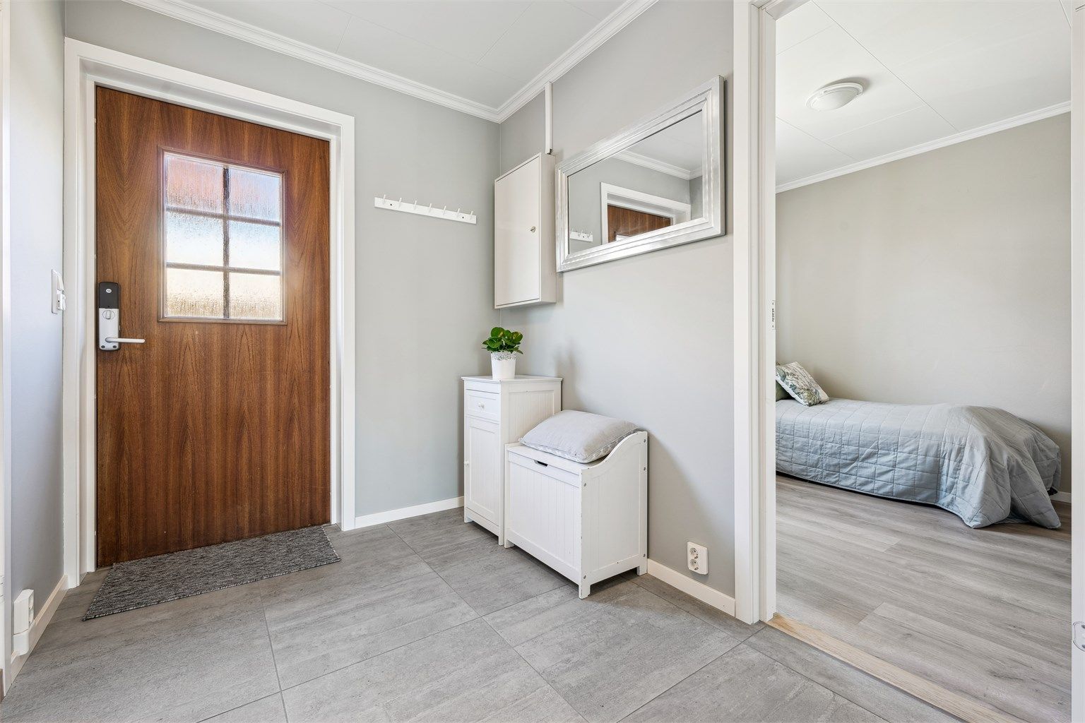 Velkommen inn i lys entré med plass til å henge fra seg yttertøy og sko