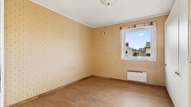 Soverom med laminatgulv og god plass til dobbeltseng.