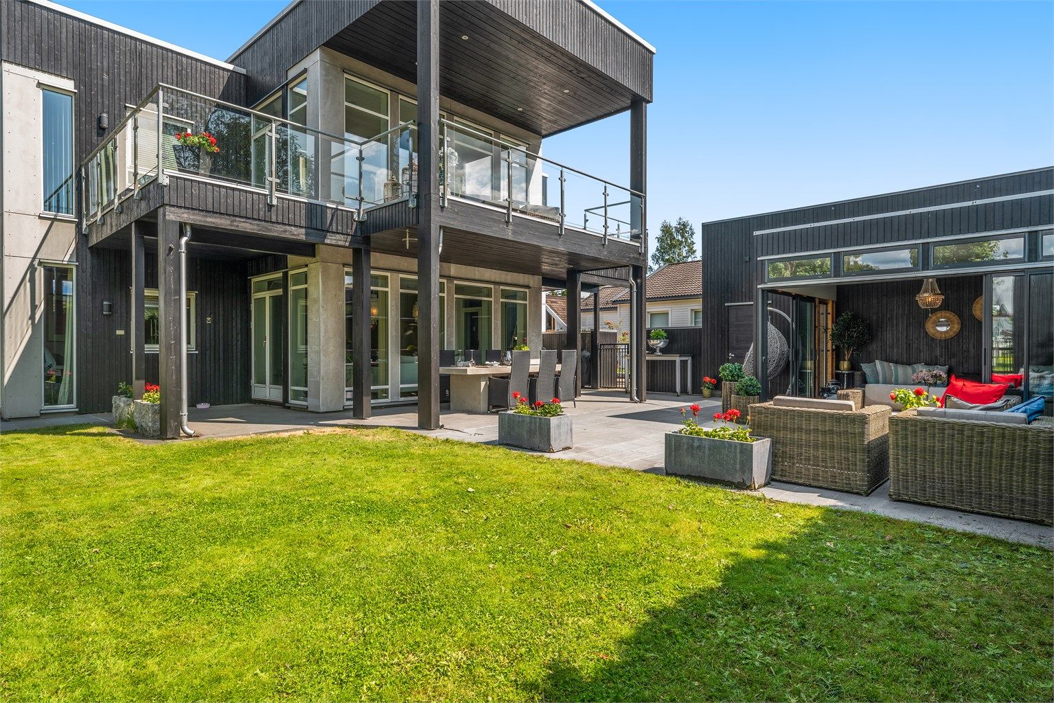 Fra stue er det adkomst til overbygget terrasseplatting på ca. 86 kvm med videre adkomst til inngjerdet hage og isolert lysthus. Terrassen har fliser, utebelysning, plassbygd betongbord, strøm og integrerte høyttalere. 