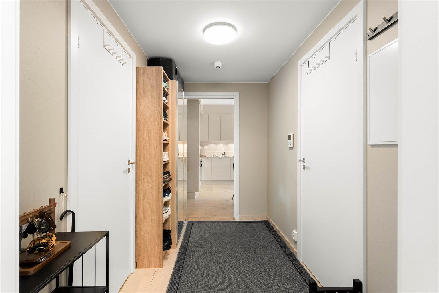 Velkommen inn! Entréen gir et innbydende førsteinntrykk med moderne overflater og en praktisk planløsning.