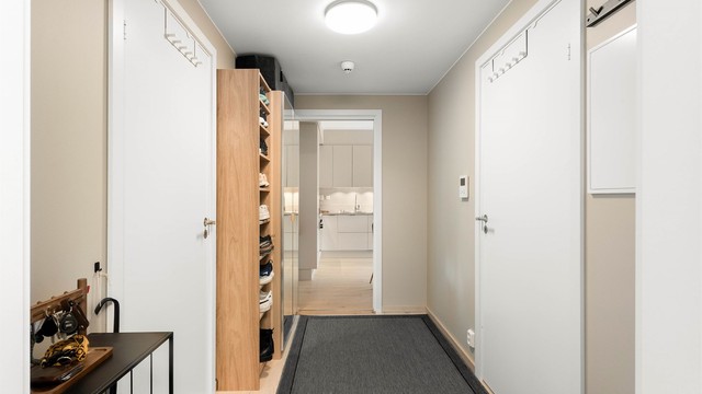 Velkommen inn! Entréen gir et innbydende førsteinntrykk med moderne overflater og en praktisk planløsning.