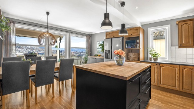 Kjøkkenøya gir ekstra arbeidsflate og oppbevaring. Fra spiseplassen kan utsikten nytes under måltidene.
