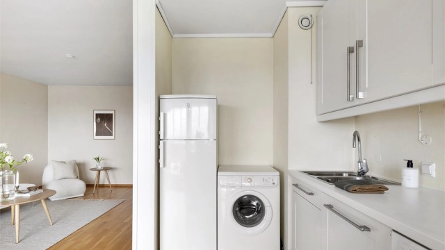 Praktisk nisje med plass til kjøleskap og vaskemaskin på kjøkkenet.