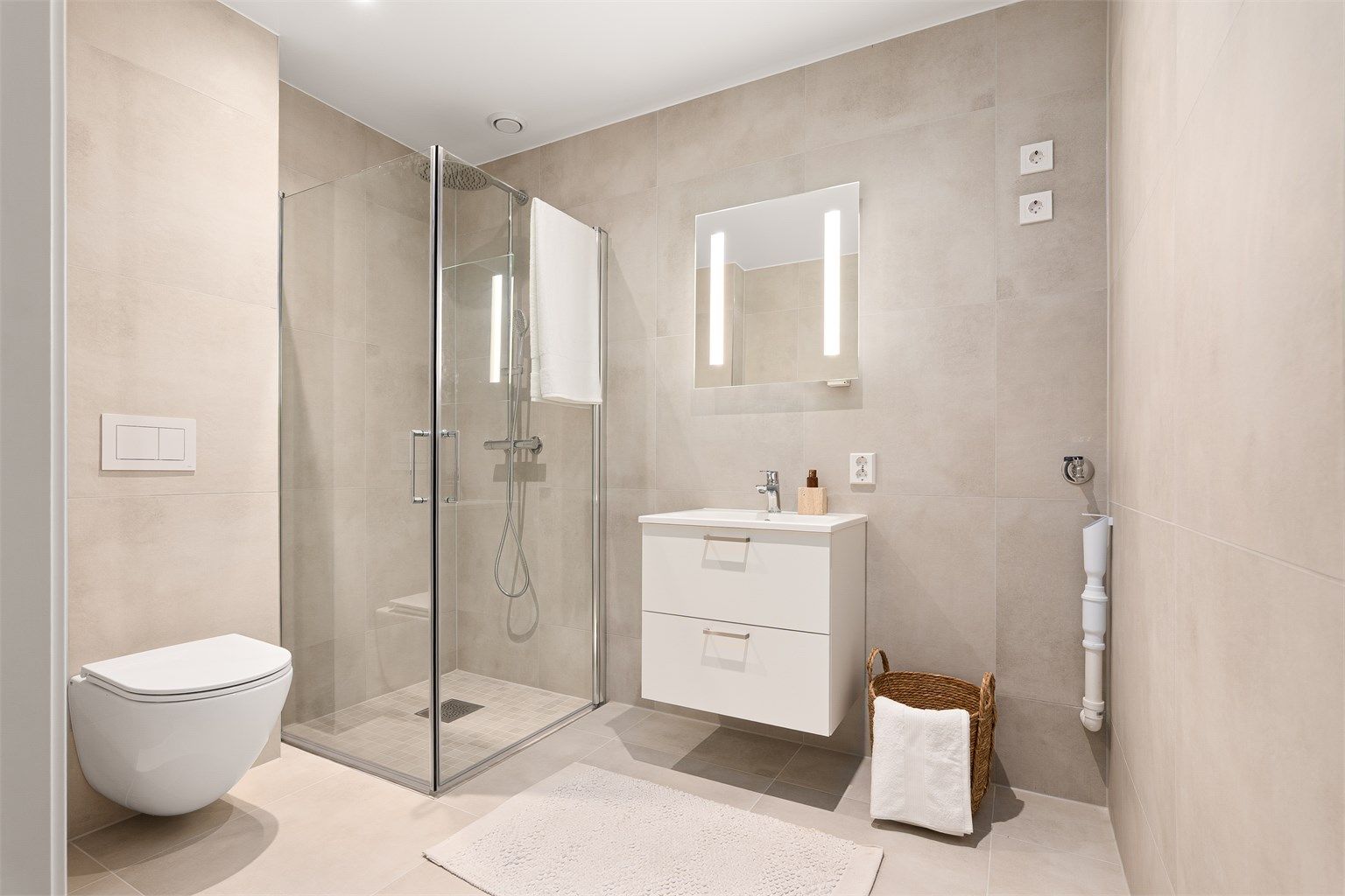 Badet har i likhet med kjøkkenet kvalitetsmøbler i serien Snøtinden fra Strai. Gulvet og veggene er utført med moderne fliser, gulvet også med varmekabler.