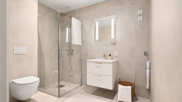 Badet har i likhet med kjøkkenet kvalitetsmøbler i serien Snøtinden fra Strai. Gulvet og veggene er utført med moderne fliser, gulvet også med varmekabler.