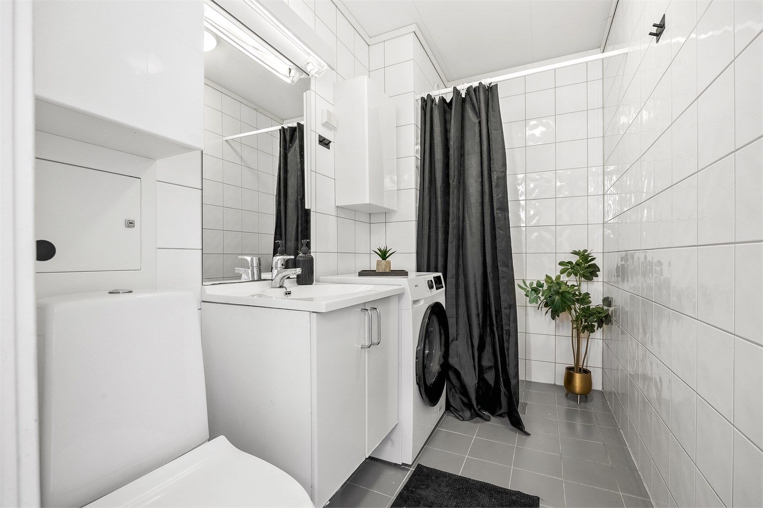 Flislagt bad med gulvvarme og opplegg for vaskemaskin.