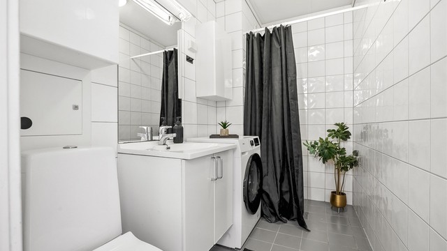 Flislagt bad med gulvvarme og opplegg for vaskemaskin.