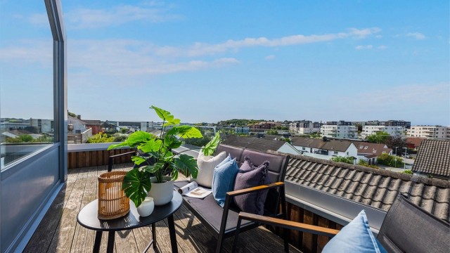 Balkongen strekker seg rundt deler av boligen. I tillegg har man uteplass ved inngangsparti.