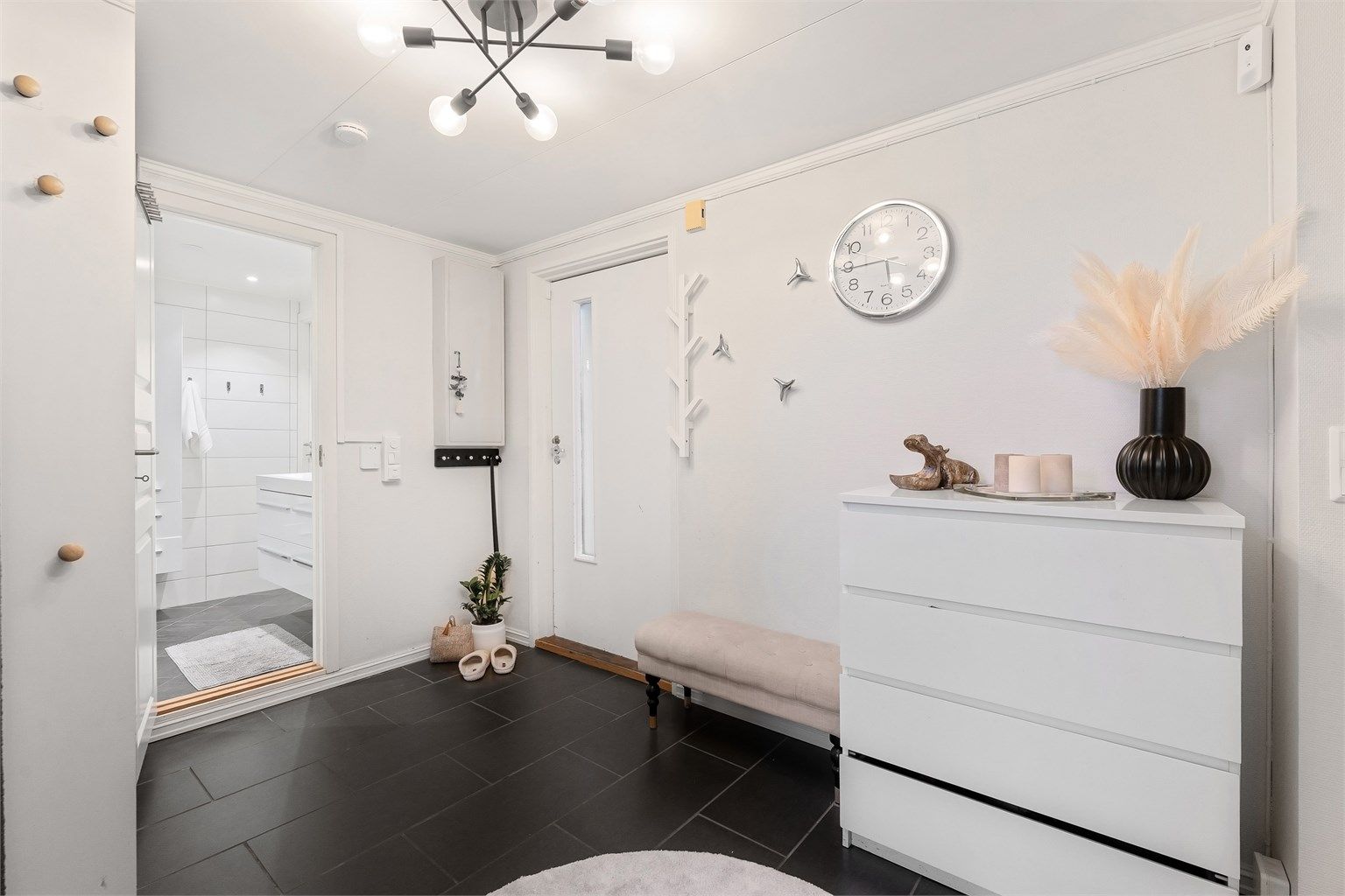 Boligen har en romslig entre med direkte tilgang til bad og til det store kjøkkenet