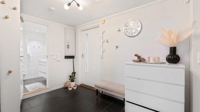 Boligen har en romslig entre med direkte tilgang til bad og til det store kjøkkenet