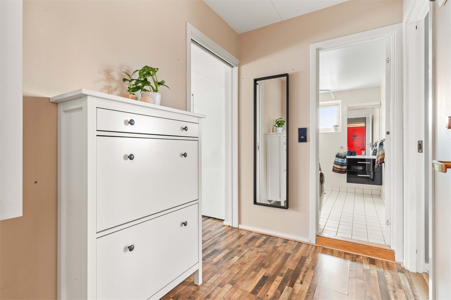 Fra entréen er det direkte tilgang til badet og videre inn til leilighetens oppholdsrom.