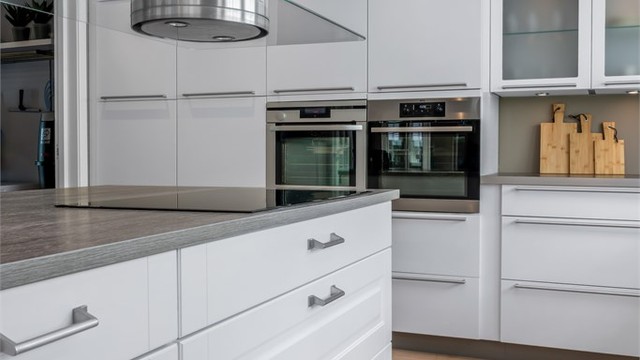 Kjøkkenøy med induksjonstopp og ventilator er en praktisk arbeidsflate og et naturlig samlingspunkt.