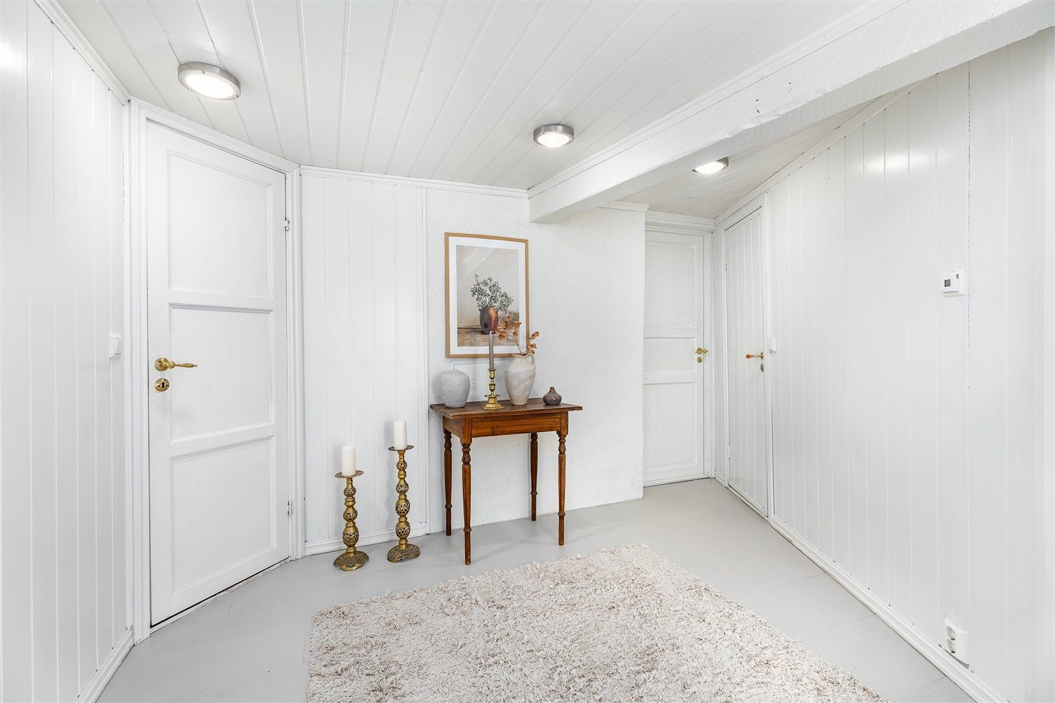 Omkring den romslige hallen finnes foruten badet og vaskekjelleren også kott og boder med lagringsplass. 