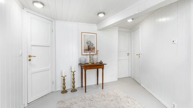 Omkring den romslige hallen finnes foruten badet og vaskekjelleren også kott og boder med lagringsplass.