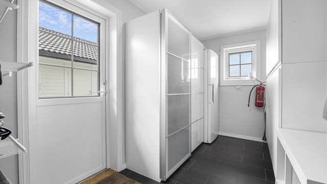 Boligen har en praktisk bi-inngang via en innvendig bod, som gir rikelig med lagringsplass.
