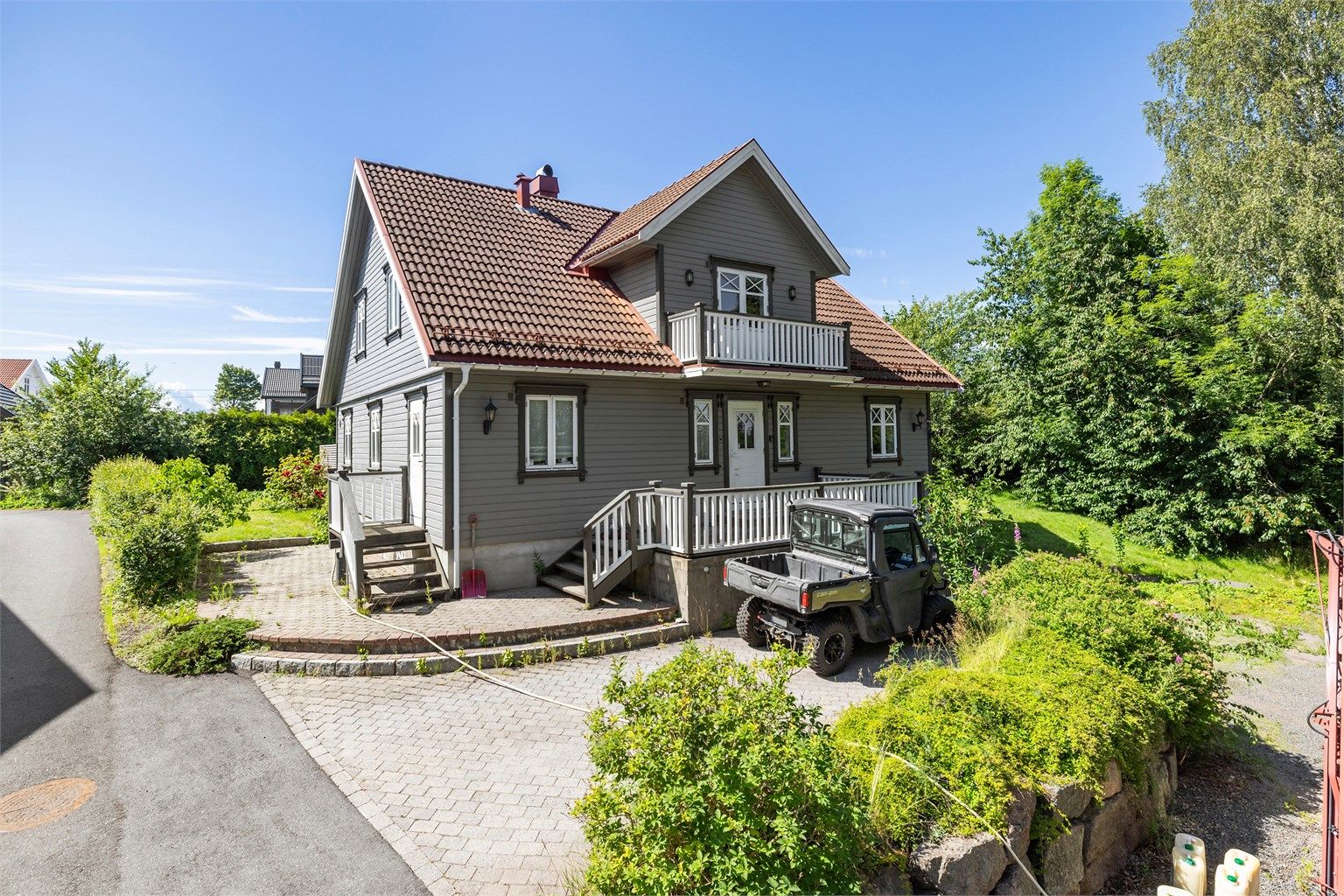 Eiendommen ligger på en hellende tomt med en stor, opparbeidet hage og gode solforhold.