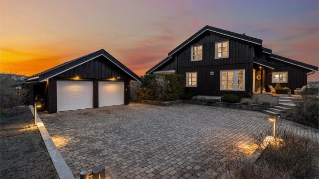 Boligen har en flott, steinlagt gårdsplass med dobbelgarasje. Det er i tillegg en annen garasje på eiendommen. Foto: Trond Reder