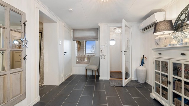 Den romslige hallen i underetasjen har flislagt gulv med gulvvarme