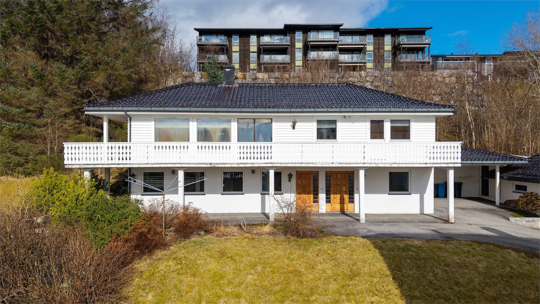 Eneboligen har liggende bordkledning og tak tekket med tegltakstein