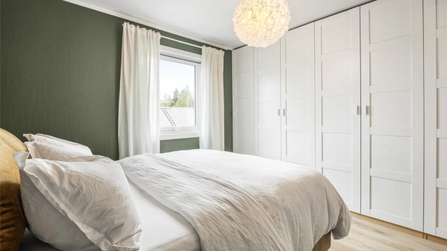 Hovedsoverommet har en romslig garderobeløsning i hvit og profilert utførelse.